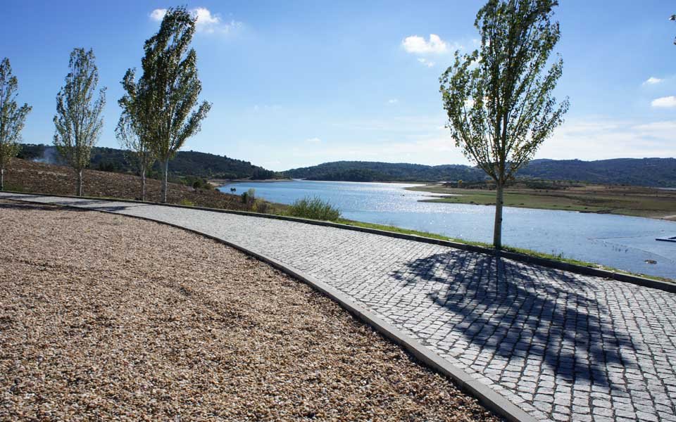 Bordure granit délimitant une allée pavée au bord de l'eau